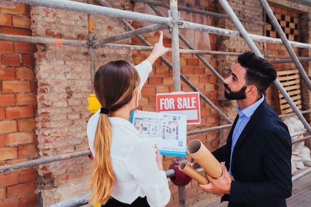 Two individuals examining a building